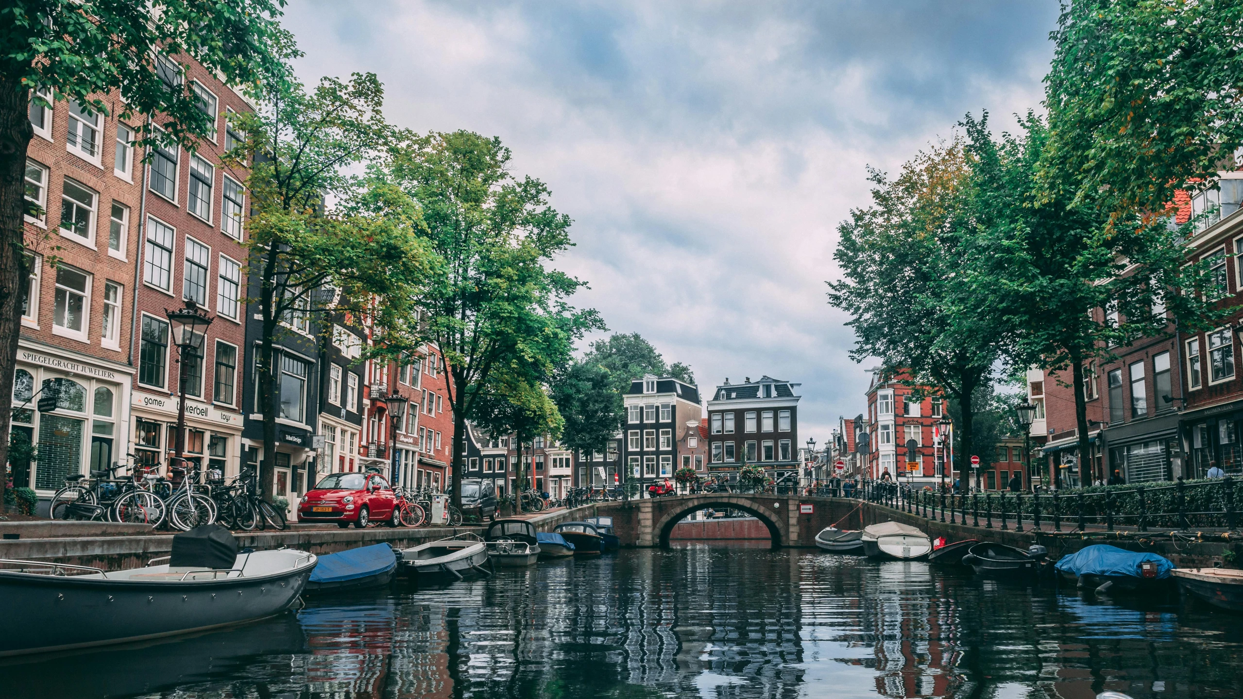 a canal filled with lots of boats next to tall buildings, by Maria van Oosterwijk, pexels contest winner, art nouveau, dutch houses along a river, thumbnail, seasonal, slide show