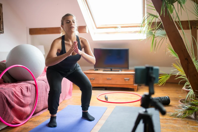 a woman standing on a yoga mat with a hula hoop, unsplash, tv still, sitting on bent knees, avatar image, lunging at camera :4