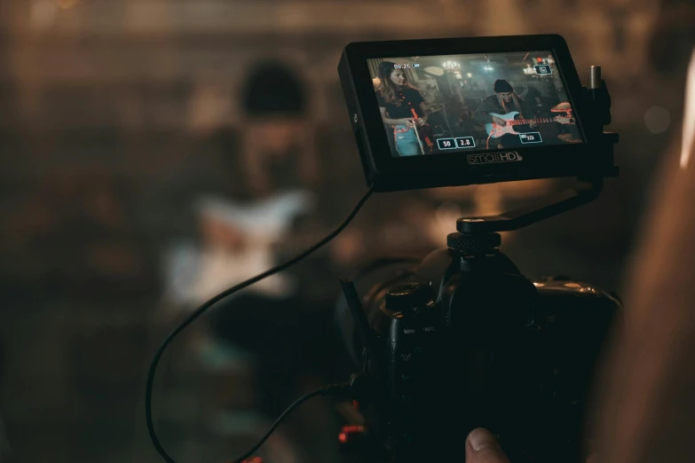 a close up of a person holding a camera, performing a music video, lcd screen, focus on the musicians, promotional image