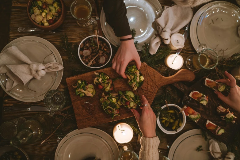 a group of people sitting around a dinner table, pexels contest winner, on a wooden plate, seasonal, thumbnail, mid night