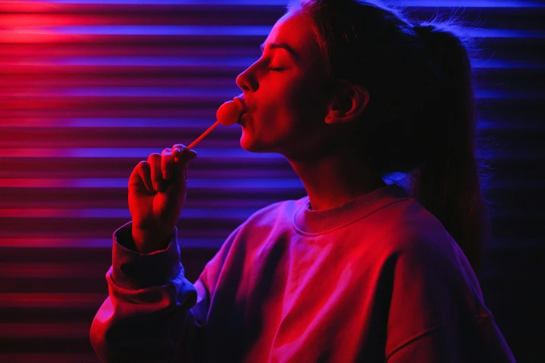 a woman smoking a cigarette in a dark room, inspired by Elsa Bleda, pexels contest winner, an ewok eating a lollipop, red and blue neon, synth wave, red and purple