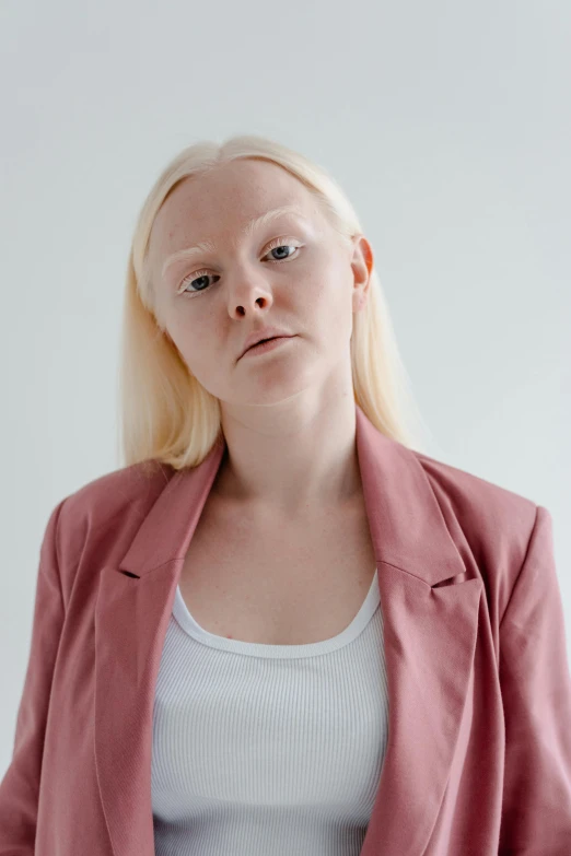 a woman with blonde hair wearing a pink blazer, inspired by Louisa Matthíasdóttir, emaciated shaved face, frowning expression, albino, lena oxton