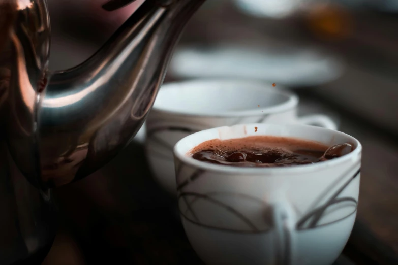 a close up of a cup of coffee on a table, fully chocolate, some pouring techniques, secret tea society, stew