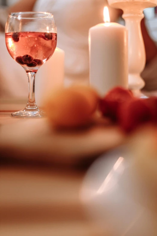 a glass of wine sitting on top of a table, a still life, pexels, “berries, sweet night ambient, pink, morning detail