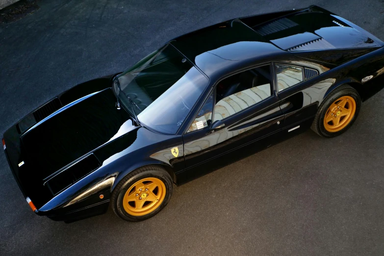 a black sports car parked in a parking lot, by Brian Thomas, pexels contest winner, photorealism, with elements of the f40, high - angle view, profile, golden detailing