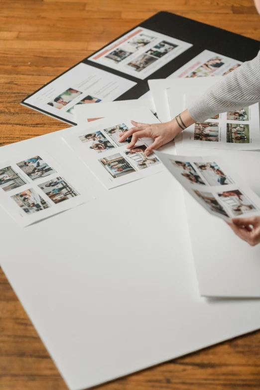 a woman sitting on top of a wooden floor next to a pile of photos, a picture, by Matthias Stom, trending on unsplash, glowforge template, on white paper, high angle close up shot, panels