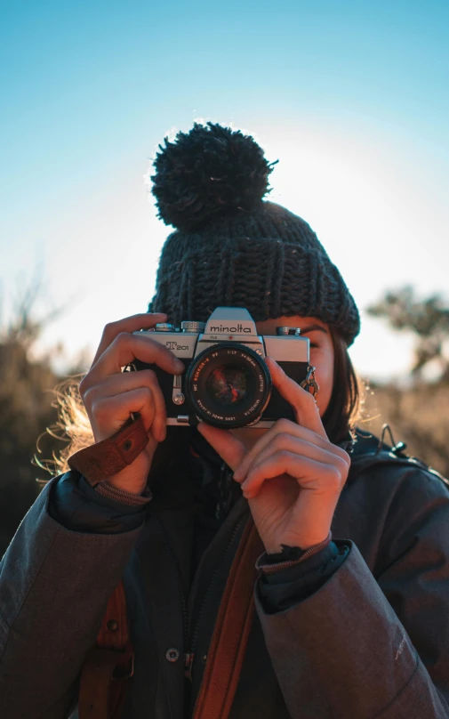 a woman taking a picture with a camera, a picture, by Robbie Trevino, low quality photo, explorer, cute photograph, cinematic outfit photo