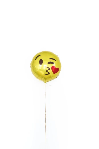a yellow balloon with a smiley face on it, a picture, gold foil, kiss, new emoji of biting your lip, brown