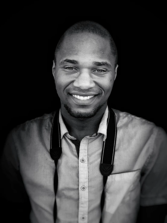 a black and white photo of a man smiling, by Daniel Gelon, happening, david uzochukwu, smiling and looking directly, biological photo, well lit professional photo