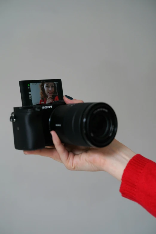 a close up of a person holding a camera, lcd screen, posing for the camera, posing for a picture, sony a 6 3 0 0