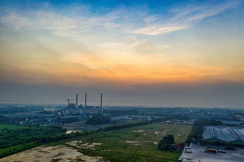 an aerial view of a factory with a sunset in the background, pexels contest winner, south jakarta, fan favorite, panoramic photography, print ready