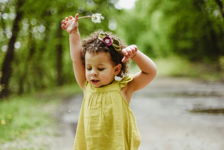 a little girl with a flower in her hair, pexels contest winner, lady using yellow dress, toddler, wearing green clothing, fairy dust in the air