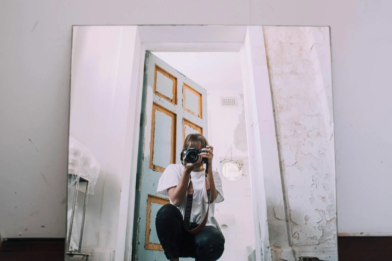 a person taking a picture of themselves in a mirror, a picture, inspired by Elsa Bleda, pexels contest winner, minimalism, sitting on the floor, leaning on door, full body shot 4k, medium format camera