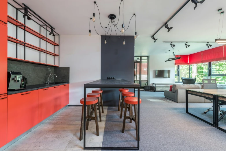 a kitchen with a black counter top and red stools, by Jan Tengnagel, unsplash contest winner, altermodern, interior of a loft, red velvet furniture, dezeen showroom, location in a apartment