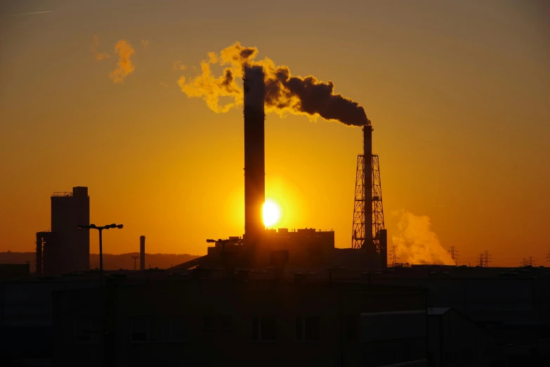 a factory with a lot of smoke coming out of it, by Joe Stefanelli, pexels contest winner, backlighting sunset golden hour, a green, carbon, islamic