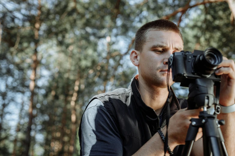 a man taking a picture with a camera, by Adam Marczyński, pexels contest winner, in front of a forest background, home video footage, ukraine. professional photo, ultra realistic. cinematic