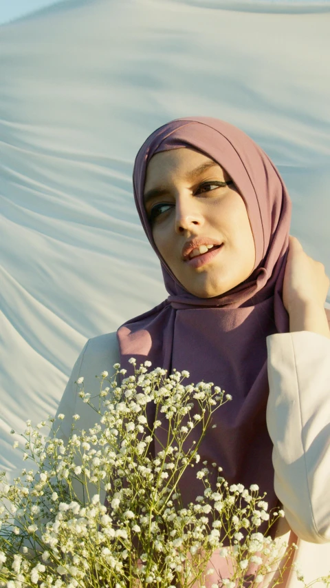 a woman in a hijab holding a bouquet of flowers, a colorized photo, trending on pexels, hurufiyya, her face is a mauve flower, square, 15081959 21121991 01012000 4k, wearing a long flowy fabric