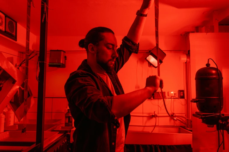 a man in a room with a red light, chemical woekshop, growing, plating, profile image