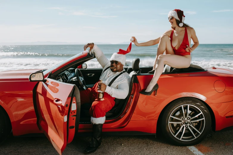 a man sitting on top of a car next to a woman, pexels contest winner, santa clause, red bikini, r&b, no watermarks