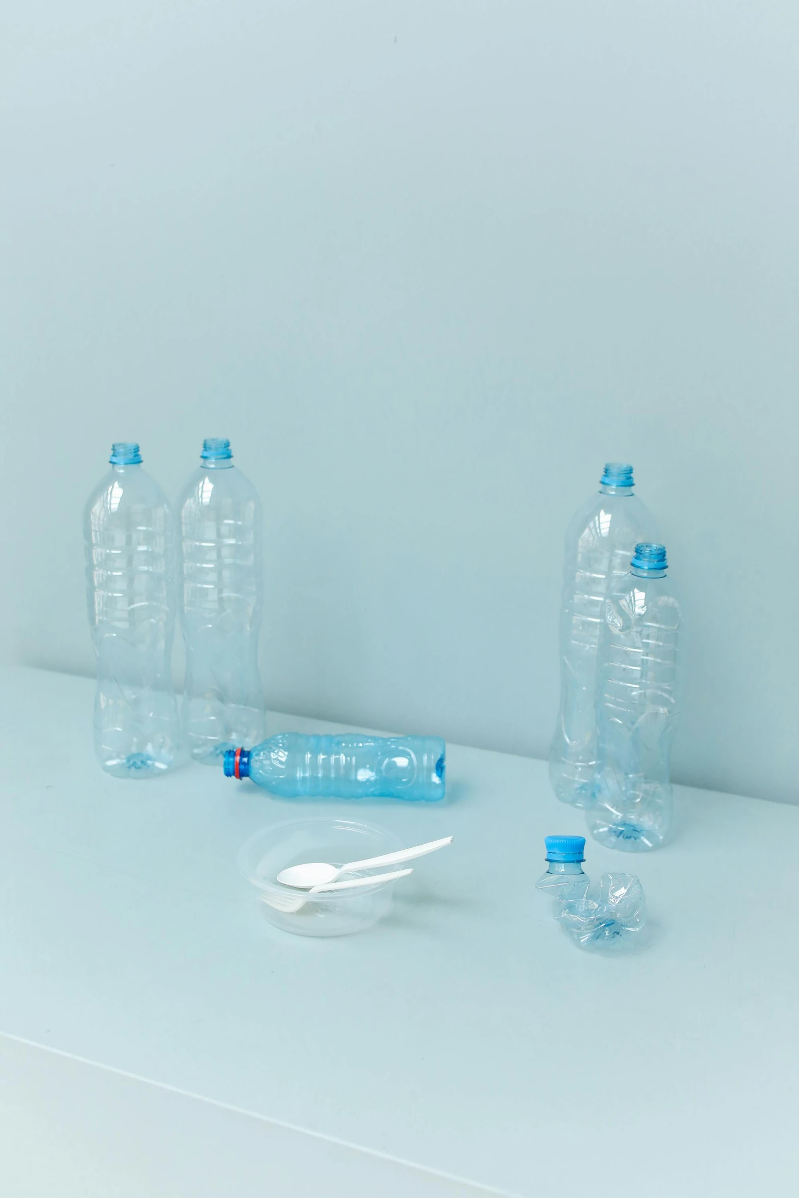 a couple of plastic bottles sitting on top of a counter, by Maeda Masao, dribble, plasticien, light-blue, 6 pack, spoon placed, various sizes