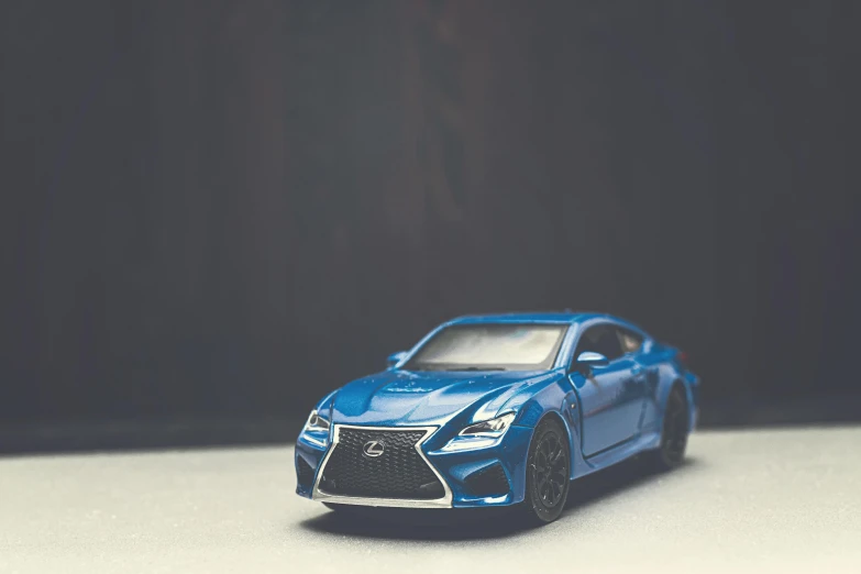 a close up of a toy car on a table, by Adam Rex, pexels contest winner, kobalt blue, sportcar, instagram picture, front lit