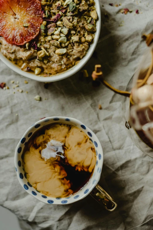 a couple of bowls of food sitting on top of a table, a portrait, trending on unsplash, maple syrup & hot fudge, thumbnail, gold, big oatmeal