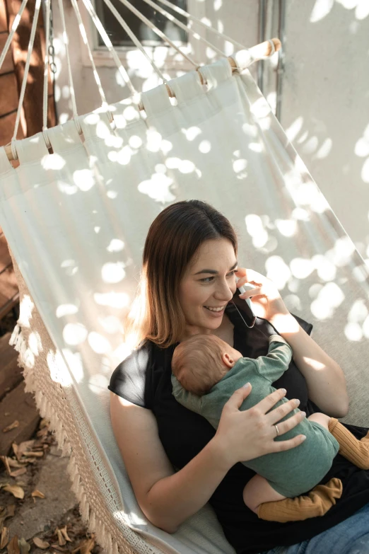 a woman sitting in a hammock holding a baby, happening, profile image, flatlay, soft internal light, hero shot