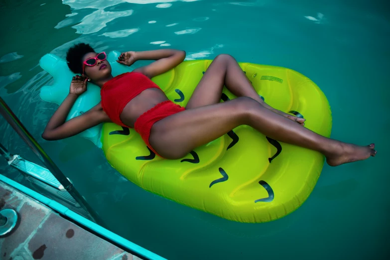 a woman laying on an inflatable raft in a pool, by Julia Pishtar, pexels contest winner, pop art, slimer, dark skinned, full body image, is wearing a swimsuit