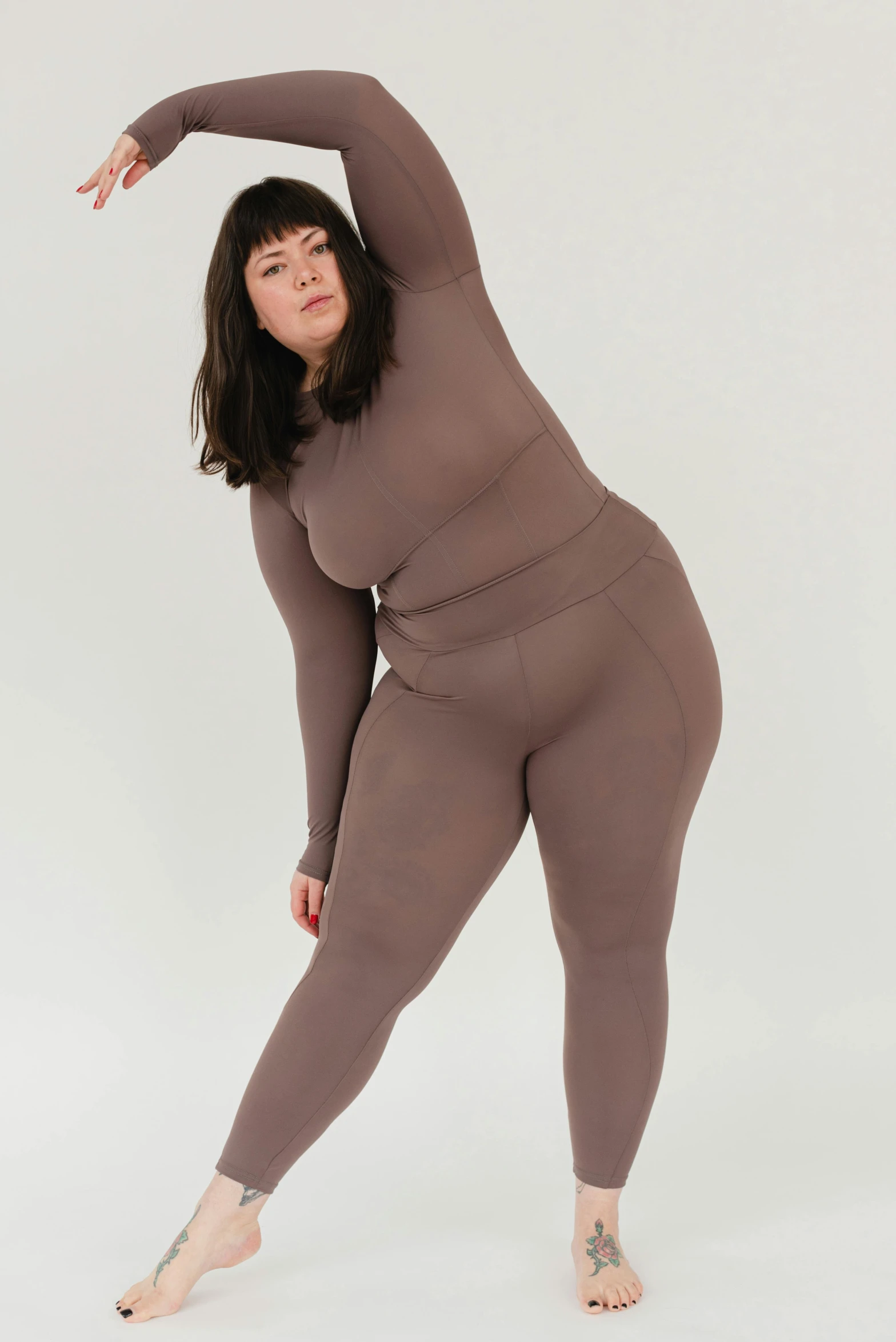 a woman in a brown outfit poses for a picture, curvy build, wearing fitness gear, soami, designed for cozy aesthetics!