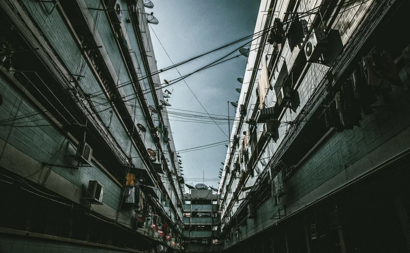 a street filled with lots of tall buildings, inspired by Elsa Bleda, pexels contest winner, brutalism, attached to wires. dark, chinese building, “derelict architecture buildings, floating buildings