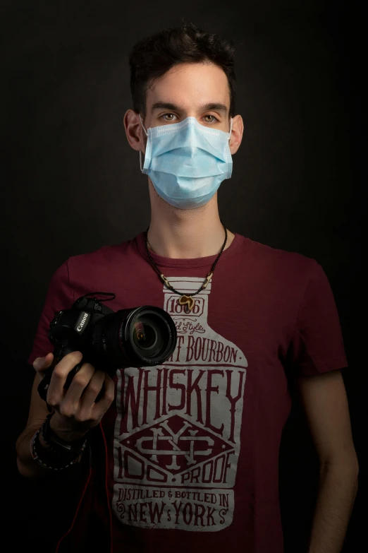 a man wearing a mask and holding a camera, by Adam Marczyński, reddit, art photography, medical photography, discord profile picture, mid length portrait photograph, josh black