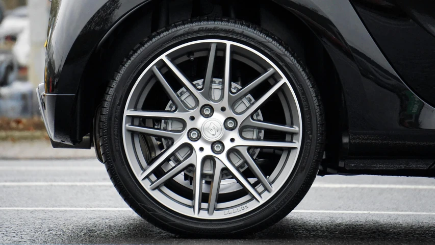 a close up of a tire on a black car, pexels contest winner, grey and silver, [ [ hyperrealistic ] ], symmetrical rim light, spherical