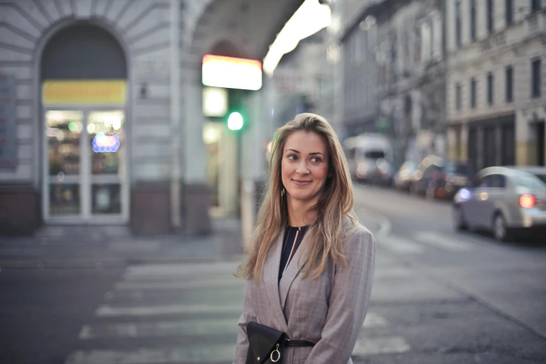 a woman standing in the middle of a street, by Emma Andijewska, smiling at camera, profile image, russian academic, business attire