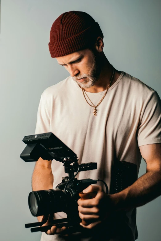 a man holding a camera in his hands, by Tom Bonson, unsplash, video art, shot with a arriflex 35 ii, cinematic headshot portrait, looking down on the camera, production ig studios