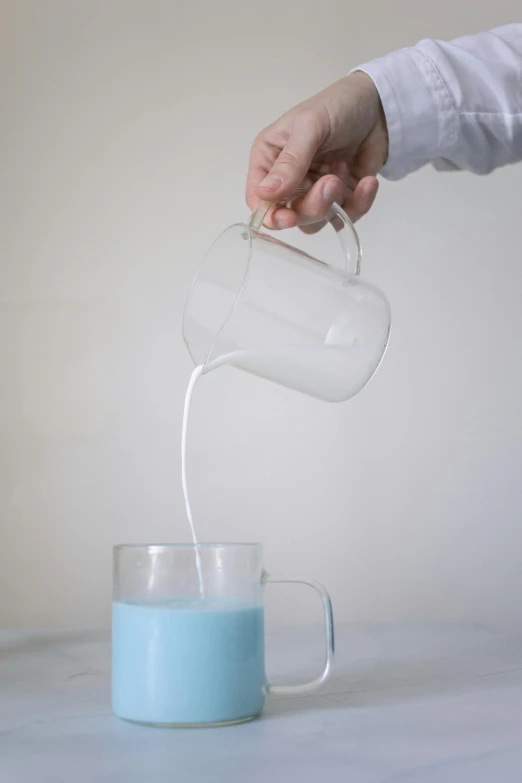 a person pouring milk into a cup on a table, pale blue, silicone skin, tall shot, transparent