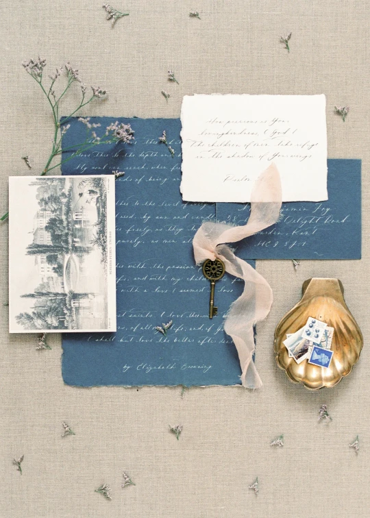 a piece of paper sitting on top of a table, inspired by Eugène Isabey, unsplash contest winner, private press, blue soft details, romantic lead, made of silk paper, flat lay