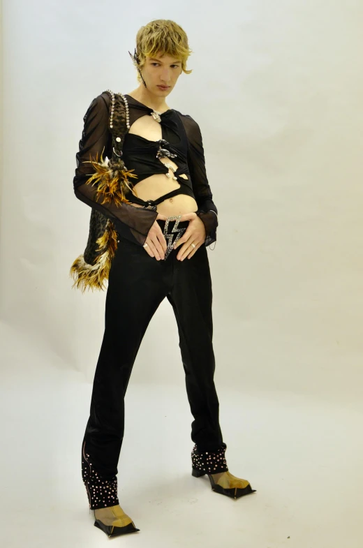 a woman in a black outfit posing for a picture, an album cover, by Gavin Hamilton, ( ( ( wearing jeans ) ) ), feather suit, non binary model, wearing chains