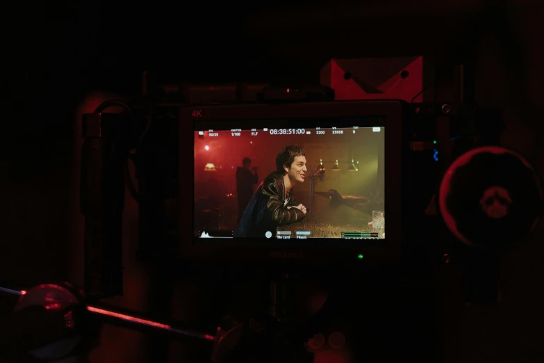 a camera on a tripod in a dark room, a picture, by Emma Andijewska, pexels, video art, joe keery, film still of gal gadot, performing a music video, color grading