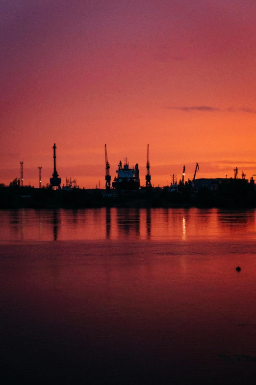 a large body of water with a sunset in the background, a picture, industrial colours, saint petersburg, vibrant colour, port