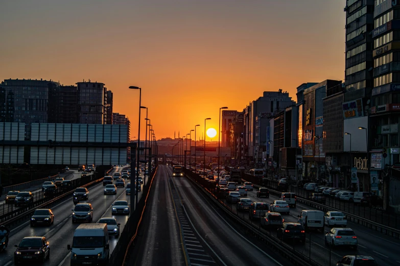 a street filled with lots of traffic next to tall buildings, by Mathias Kollros, pexels contest winner, nice sunset, turkey, highway, suns