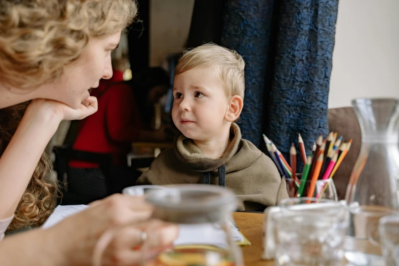 a woman and a child sitting at a table, pexels contest winner, cute boy, 15081959 21121991 01012000 4k, medium close up shot, lachlan bailey