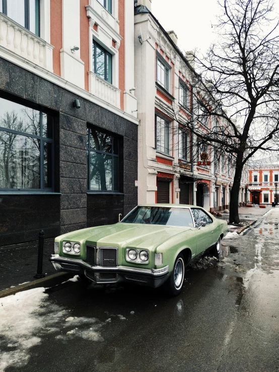 a green car parked on the side of a street, inspired by Elsa Bleda, pexels contest winner, hypermodernism, in moscow centre, bad weather, 000 — википедия, instagram picture