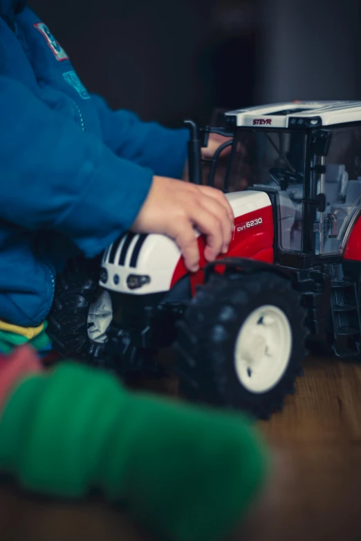 a small child playing with a toy tractor, by Andries Stock, unsplash, figuration libre, low detail, 15081959 21121991 01012000 4k