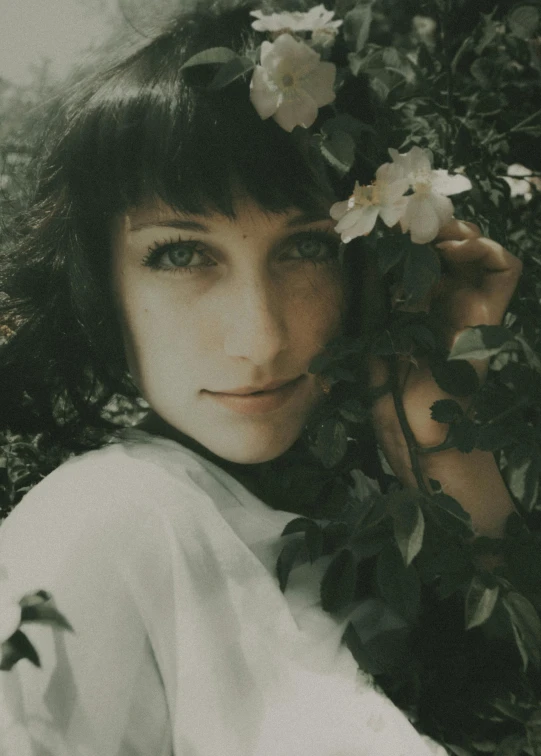 a black and white photo of a woman with flowers in her hair, inspired by Elsa Bleda, pexels contest winner, aestheticism, with deep green eyes, 4 k photo autochrome, curly bangs, amy sol in the style of