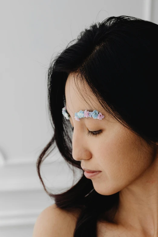 a close up of a woman holding a cell phone, a colorized photo, inspired by Xie Huan, reddit, aestheticism, jeweled ornament over forehead, pastel blues and pinks, pincushion lens effect, eeg nodes on scalp