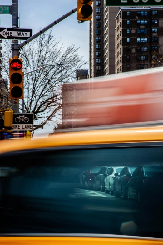 a yellow taxi driving down a street next to tall buildings, by Daniel Seghers, stacked image, square, watching new york, traffic lights