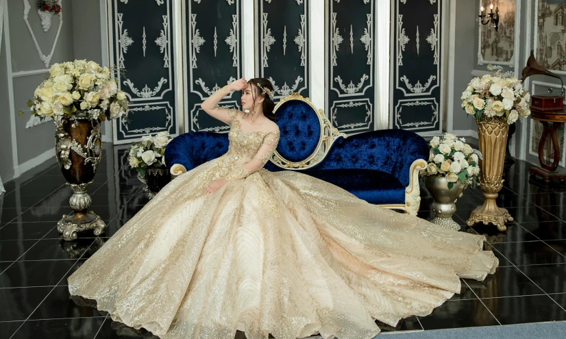 a woman in a wedding dress sitting on a blue couch, inspired by Tang Di, pixabay, baroque, glistening gold, expensive voluminous dress, taken with canon eos 5 d mark iv, elegant smiling pose