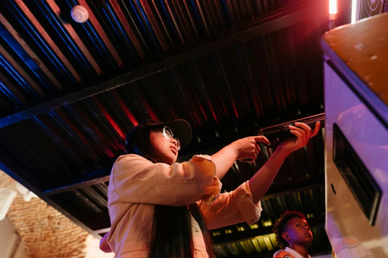 a woman taking a picture with her cell phone, an album cover, interactive art, chinatown bar, volumetric light from below, taken with sony alpha 9, people drinking beer