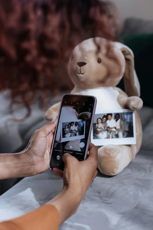 a woman taking a picture of a teddy bear, a polaroid photo, by Julia Pishtar, happening, holding a rabbit, smartphone footage, family photo, 4 k product photo