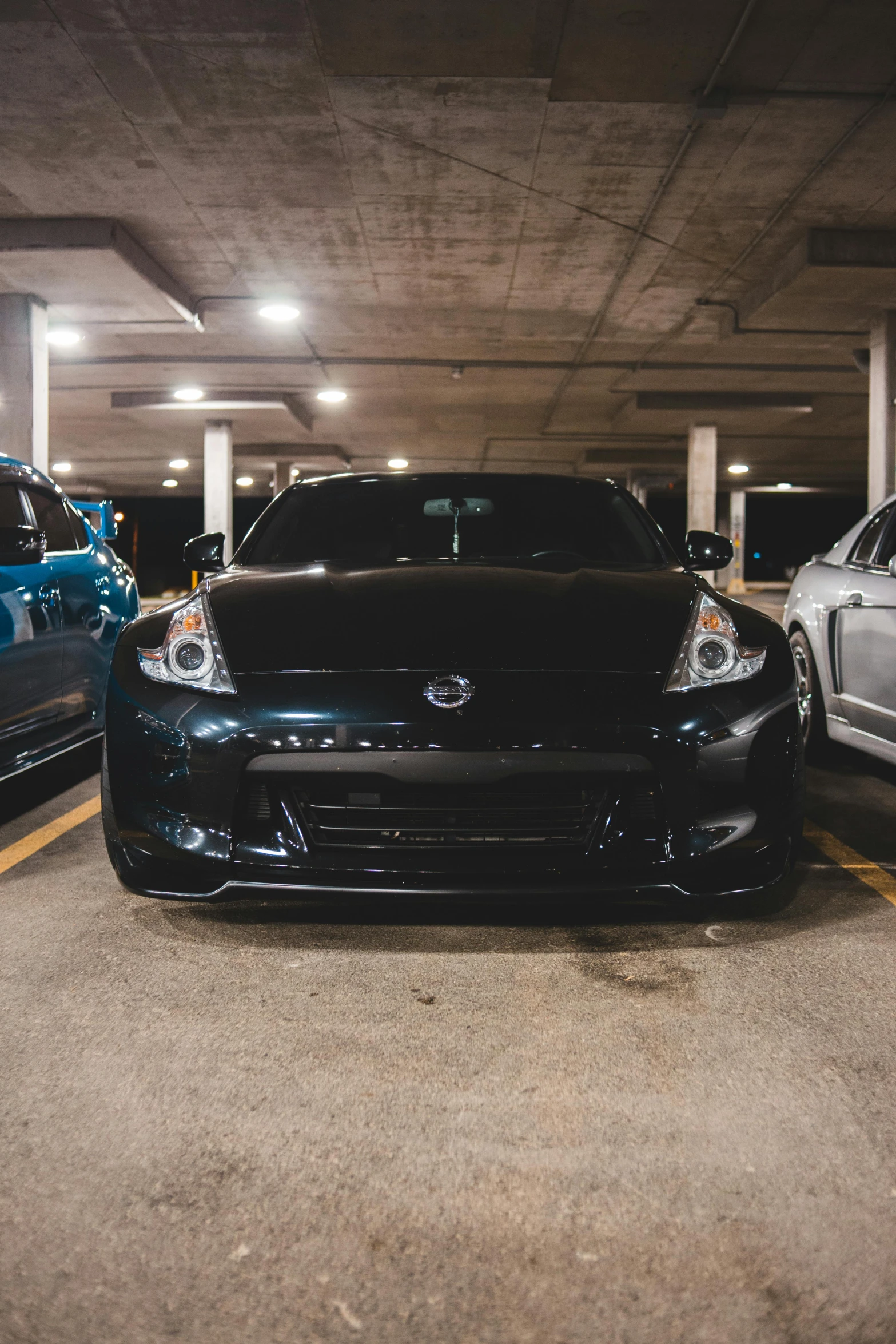 two cars parked next to each other in a parking garage, a photo, by Matt Cavotta, unsplash, full face frontal centered, jdm, square, black car